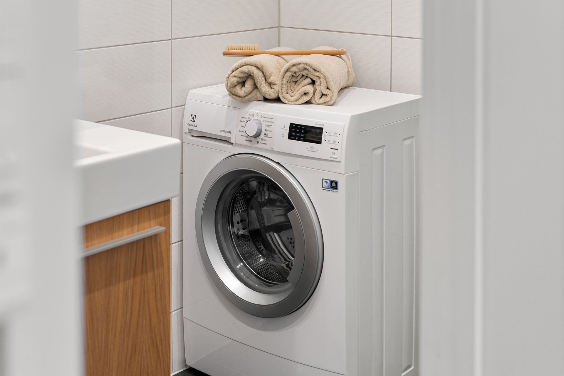 Stylish and clean laundry space featuring a white washing machine with towels on top.