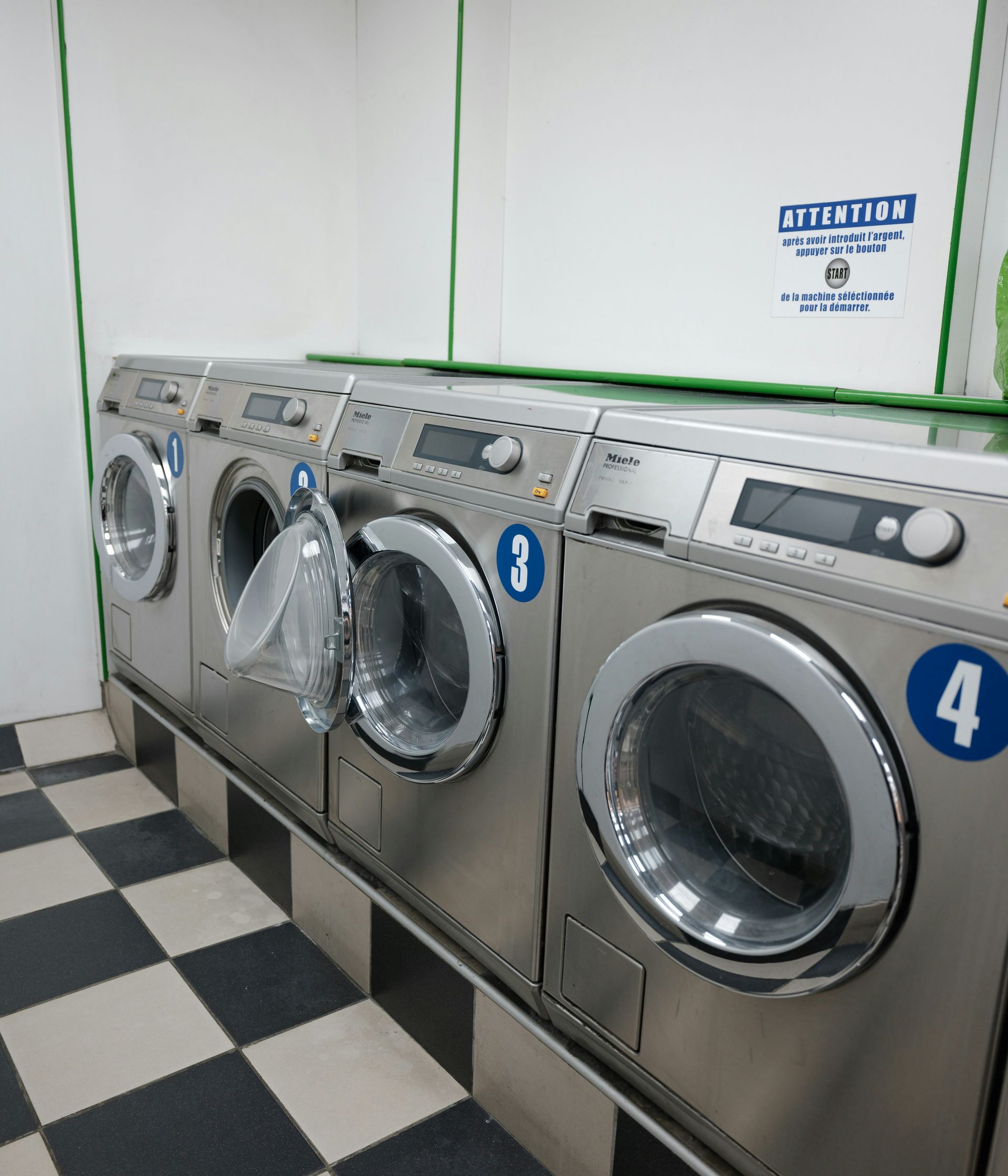 Row of silver washing machines in a laundromat